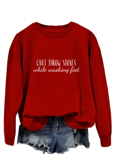 Détail du sweat-shirt rouge à imprimé blanc et du short en jean bleu délavé