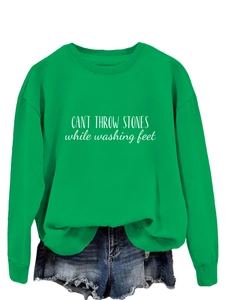 Détail d'un sweat vert avec texte blanc et short en jean aux bords effilochés