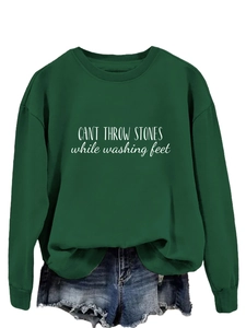 Détail d'un sweat vert foncé avec texte blanc et mini-short en jean délavé