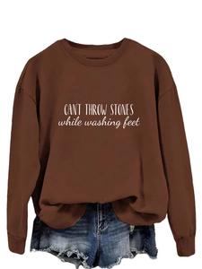 Détail du sweat marron avec imprimé CAN'T THROW STONES et short en jean bleu