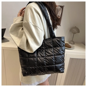 Detail of the black quilted puffer tote bag featuring oversized checkerboard stitching patterns