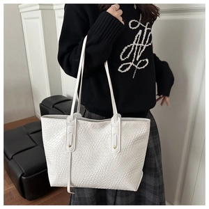 Detail of white animal-embossed tote bag with slim shoulder straps for a stylish commute