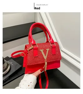 Detail of red leather crossbody bag with glitter flap, gold V logo and tassel charm