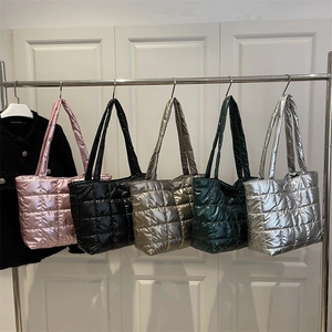 Quilted puffer tote bags in five metallic colors hanging on a silver rack for daily use