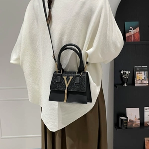 French style black crossbody bag with gold V-shaped metal logo and tassel decoration
