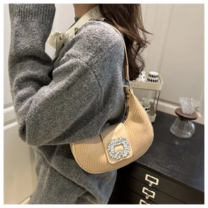 Gros plan détaillé du sac hobo en velours côtelé beige avec boucle en cristal étincelant