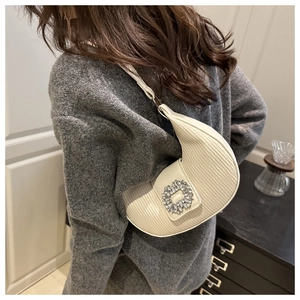 Détail du sac à bandoulière demi-lune blanc avec texture plissée et boucle en cristal