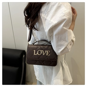 Detail of quilted leather crossbody bag with LOVE metal logo shown on model shoulder