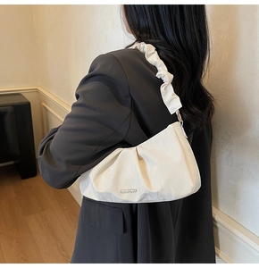 Dettaglio della borsa a nuvola bianca plissettata con trama in velluto e logo in metallo