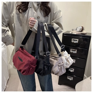 Detailed view of minimalist nylon bags in wine red, black, and khaki with adjustable straps