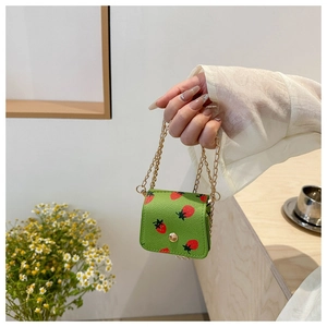 Détail de l'imprimé fraise sur le mini sac à chaîne en cuir vert à texture lychee