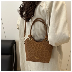 Brown leopard print bucket bag detail showing fashion logo and matte texture material
