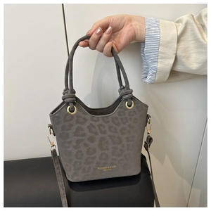 Detail of grey bucket bag with leopard embossing and elegant knot handle design