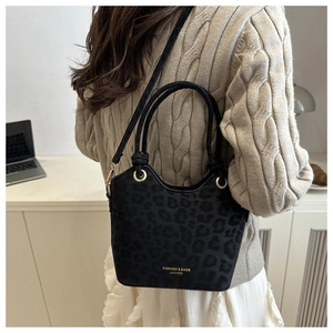 Fashionable black leopard print bucket bag with gold eyelets and leather strap detail