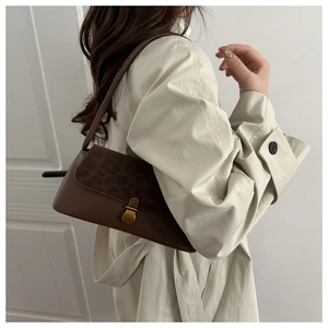 Detail of vintage leopard print patchwork on brown shoulder bag with gold metal buckle