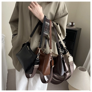 Detail view of four small retro tote bags in black, brown, and cream with jacquard straps