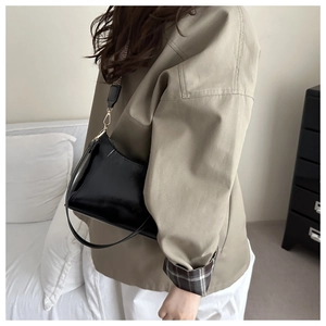 Detail der schwarzen Lackleder-Tasche mit Vintage-Karo und schmalen Lederriemen