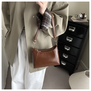 Braune Unterarmtasche aus Kunstleder kombiniert mit einem Trenchcoat im City-Look