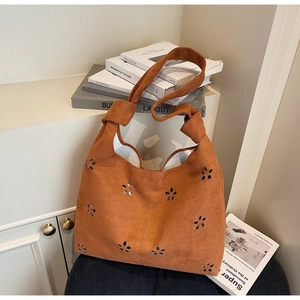 Détails du motif floral découpé au laser et du nœud sur le sac cabas en daim