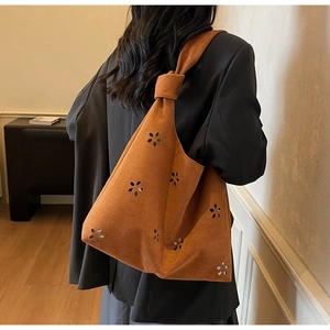 Gros plan du sac fourre-tout en daim caramel avec motifs fleurs et bandoulière nouée