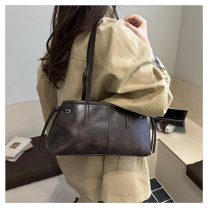 Seitenansicht der dunkelbraunen Leder-Shopper mit Kordelzug und verstellbarem Riemen