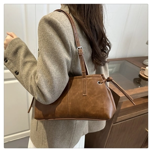 Detail of vintage brown tote bag with adjustable strap and drawstring side on model