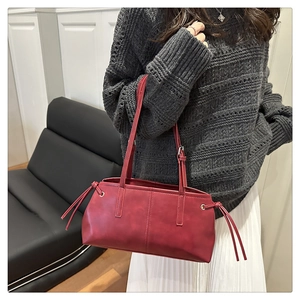 Detail view of red vintage shoulder bag with side drawstrings and dual slim straps