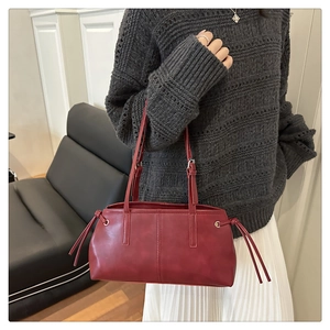 Nahaufnahme der burgunderroten Retro-Schultertasche mit silbernen Metalldetails