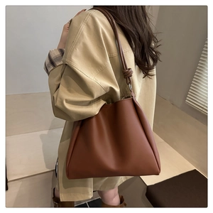 Detail of the caramel brown leather tote bag with a unique knot decorative shoulder strap