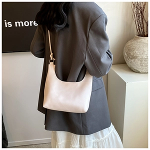 Detail of light beige hobo bag showing litchi grain texture and knotted strap design