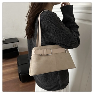 Beige suede-style tote bag with retro belt buckle worn on model's shoulder