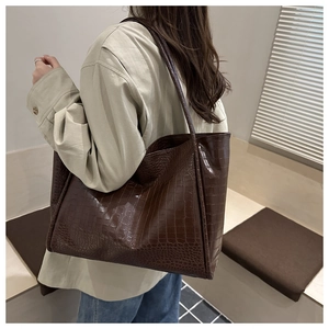 Detailed close-up showing vintage dark brown crocodile pattern texture on large tote bag