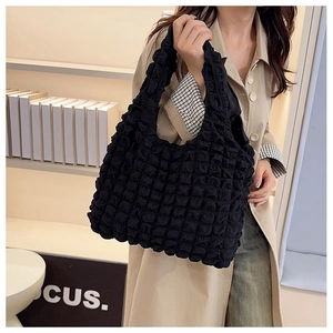 Detail of black puffer tote bag showing textured polyester fabric and spacious design