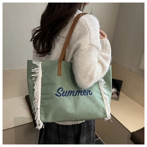 Détail du sac cabas en toile verte avec franges blanches et broderie Summer