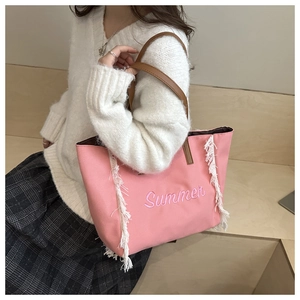 Détail du cabas en toile rose avec broderie Summer et finitions à franges blanches