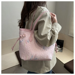 Detail of pink tote bag with wavy embroidery and embossed texture on soft PU material