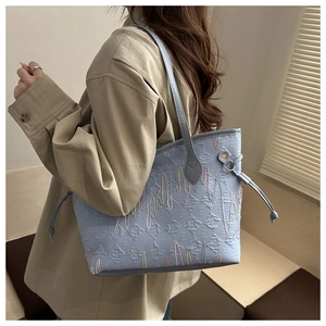 Close-up of light blue tote bag with 3D E-pattern jacquard and colorful wavy embroidery