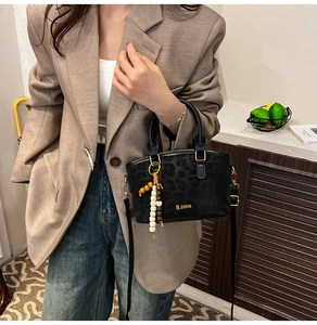 Chic black leopard print crossbody bag with colorful beads shown on model's outfit
