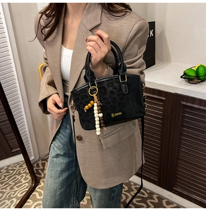 Detail of leopard print tote bag with golden JUHAI logo and beaded tassel charm