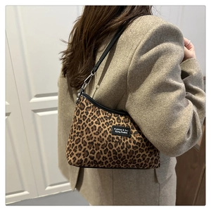 Dettaglio della borsa sottobraccio leopardata con tracolla nera e fibbie in metallo argento