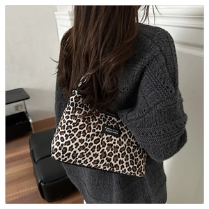 Dettaglio borsa a spalla leopardata a forma di mezzaluna con fibbie in metallo nero