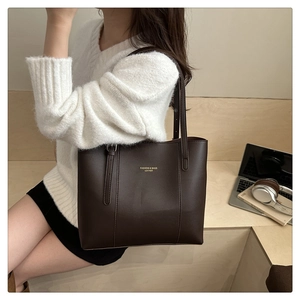 Close-up of dark brown PU leather tote bag with gold lettering logo for office styling
