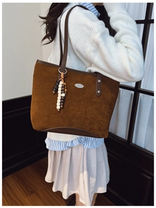 Détail du sac cabas en suédine marron caramel avec fines breloques et perles déco