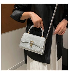 Close-up of shiny silver sequin handbag with metallic lock and elegant handle detail