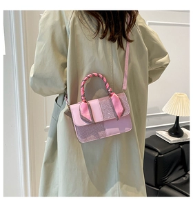 Detail view of pink sequined crossbody bag with a scarf-wrapped top handle on a model