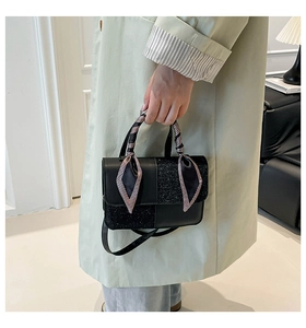 Detail of crossbody bag featuring sequined panels and houndstooth silk scarf on handle