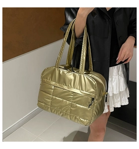 Detailed view of metallic gold quilted tote bag with soft padded square texture