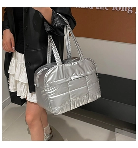 Detailed view of large silver quilted tote bag carried by model for casual daily use