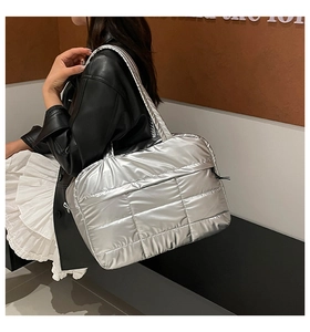 Detailaufnahme der silbernen Stepptasche getragen von einem Model im modernen Stil