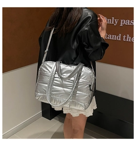 Silver quilted shoulder bag worn over a black leather jacket for a chic winter look